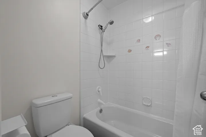 White tiled shower with built-in shelf and showerhead