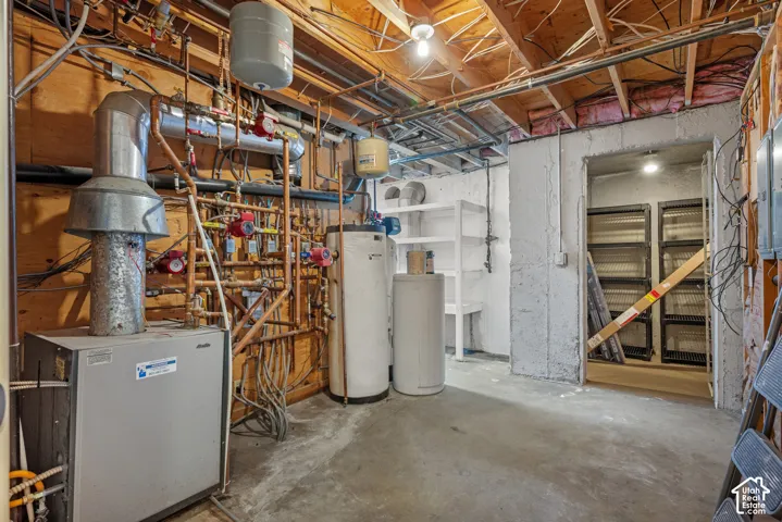 Exposed wood ceiling joists, concrete flooring, water heaters, and exposed mechanical systems