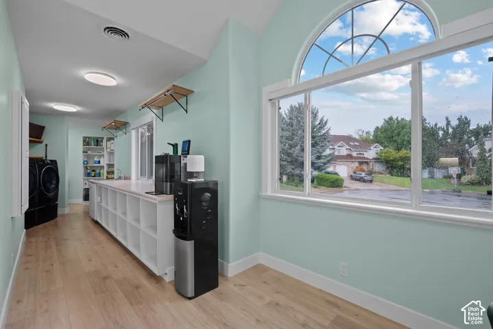 Arched window, wood-finish flooring, built-in shelving, white baseboards, flush mount lighting