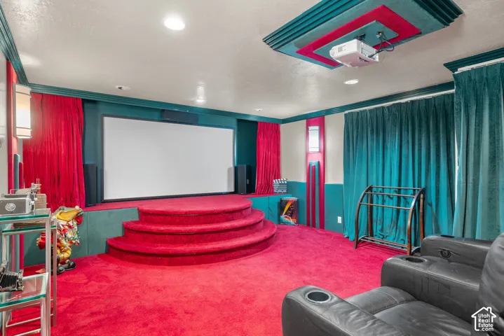 Home theater featuring a large projection screen, tiered seating platform, and recessed lighting