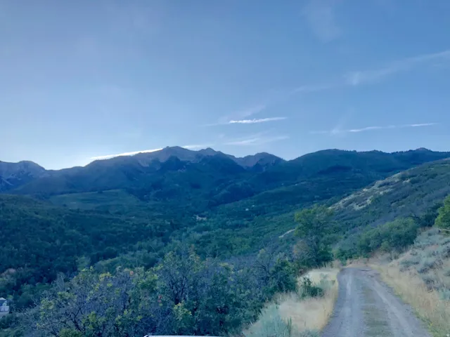 Expansive mountain range and valley landscape with a visible dirt road