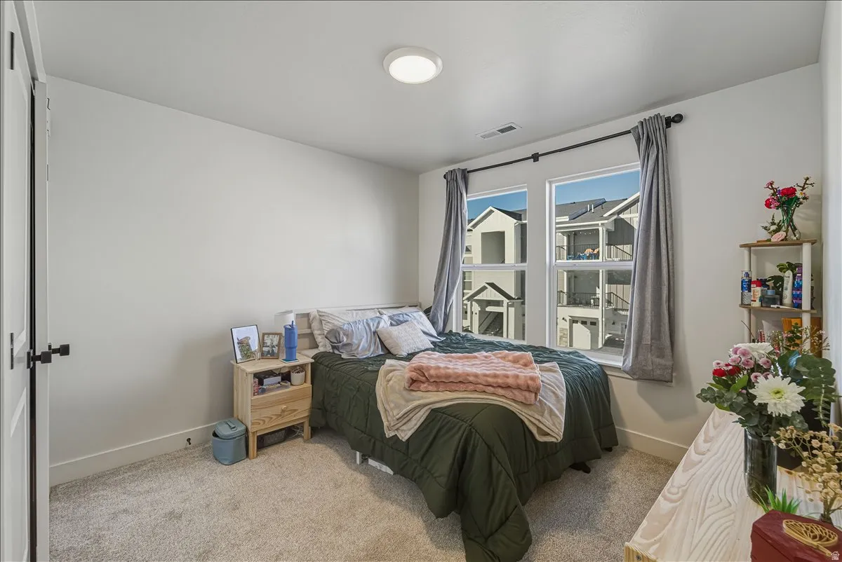 Recessed lighting, light-toned carpeting, and multiple windows with dark curtain rods