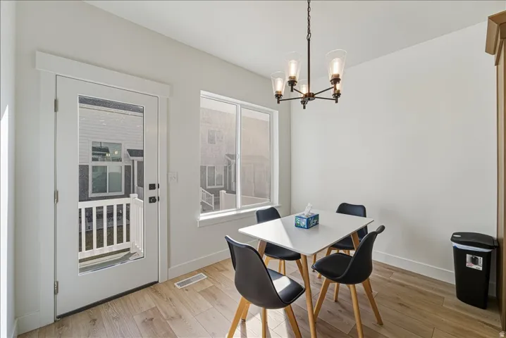 Wood-finish flooring, white walls, and a glass-paneled exterior door