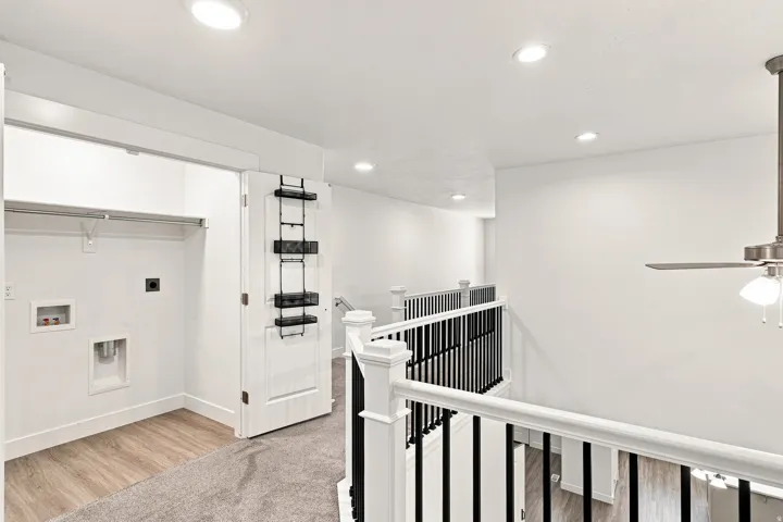 Laundry area featuring utility hookups, wood-finish flooring, and white walls