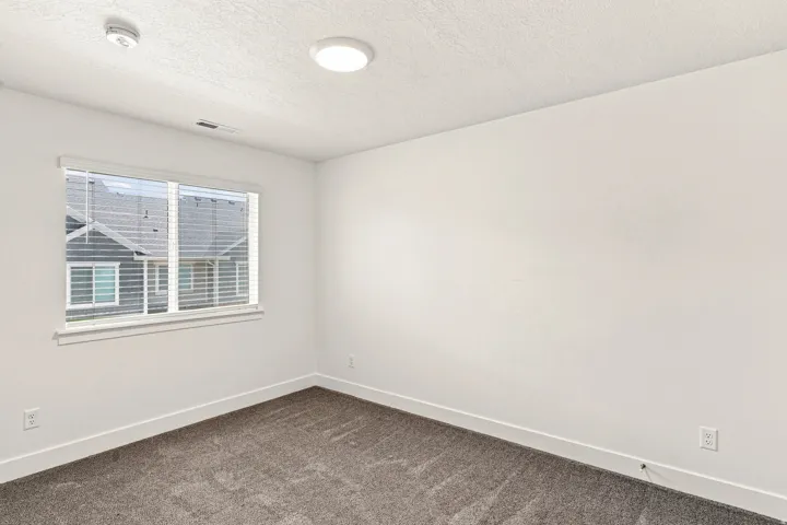 Neutral wall paint, gray carpet flooring, white window blinds, and recessed ceiling lighting