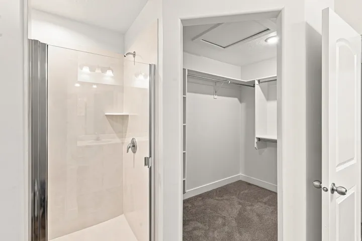 Glass-enclosed shower with a tiled surround and a built-in shelf