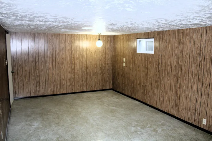 Wood-paneled walls with a light fixture and a single window