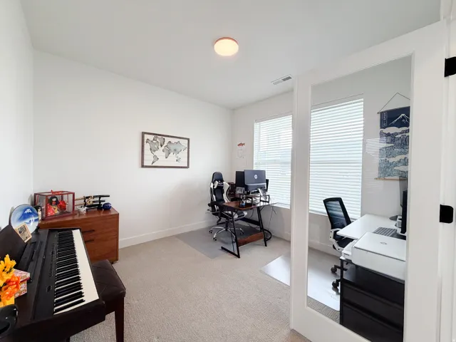 Carpeted room with white walls, a flush-mount ceiling light, and a double window with horizontal blinds