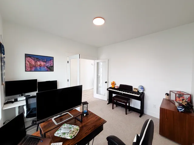 White walls, light-colored carpeting, recessed ceiling light fixture, and double French doors with frosted glass