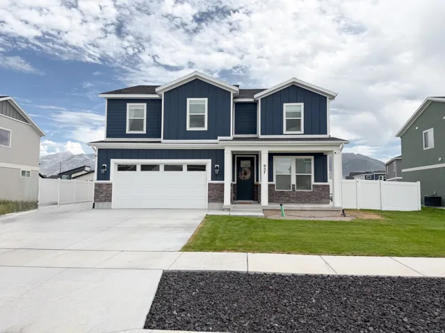 Two-story residence featuring a dark blue facade, white trim, and a stone accent foundation