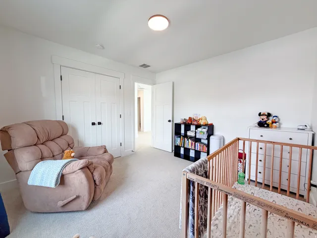 White walls with recessed lighting and neutral-toned carpeting