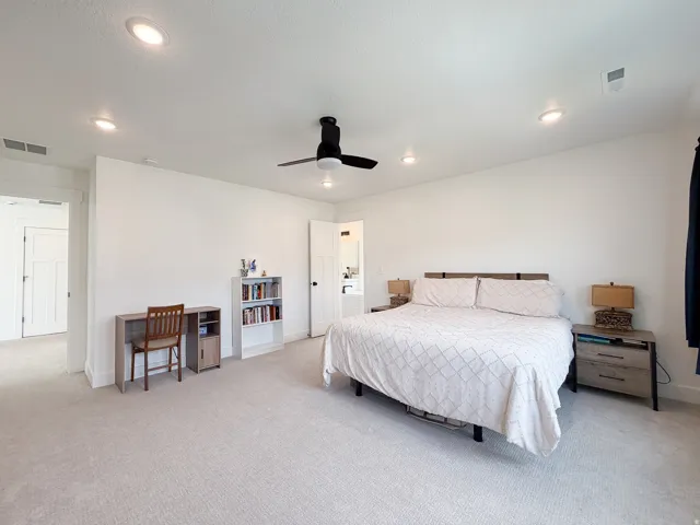 Spacious room with light-colored carpet flooring, recessed lighting, and a ceiling fan