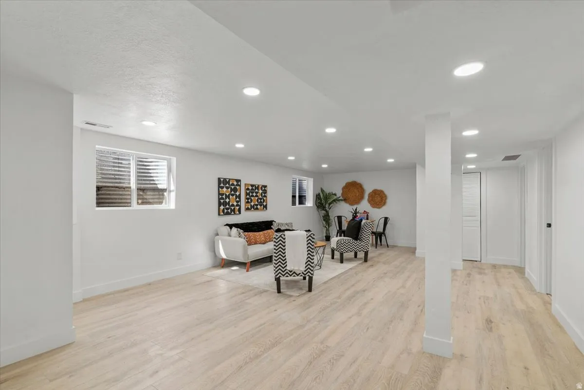 Recessed lighting illuminating a spacious room with light wood-finish flooring