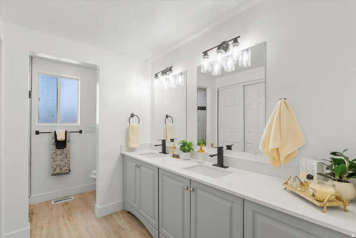 Double vanity with light gray cabinetry and white countertops
