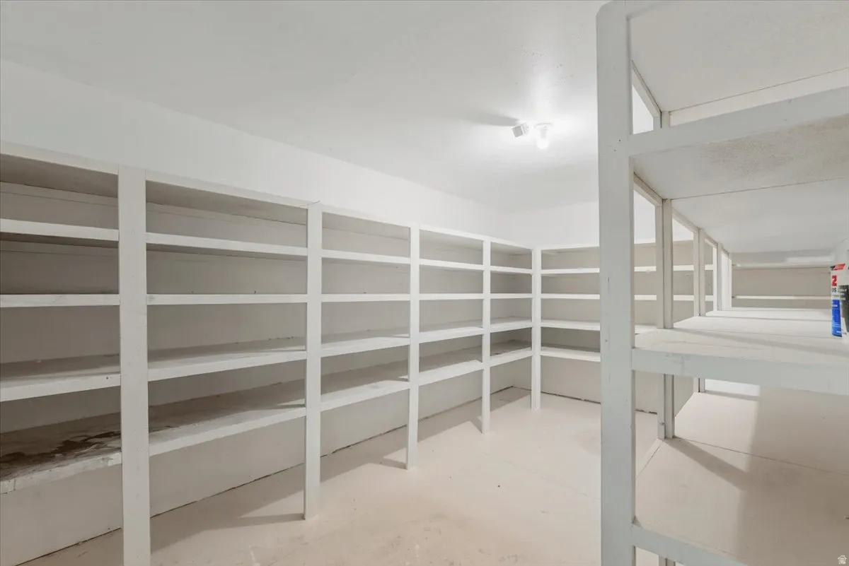 Expansive storage area featuring multiple built-in shelving units, light-colored walls, and overhead lighting