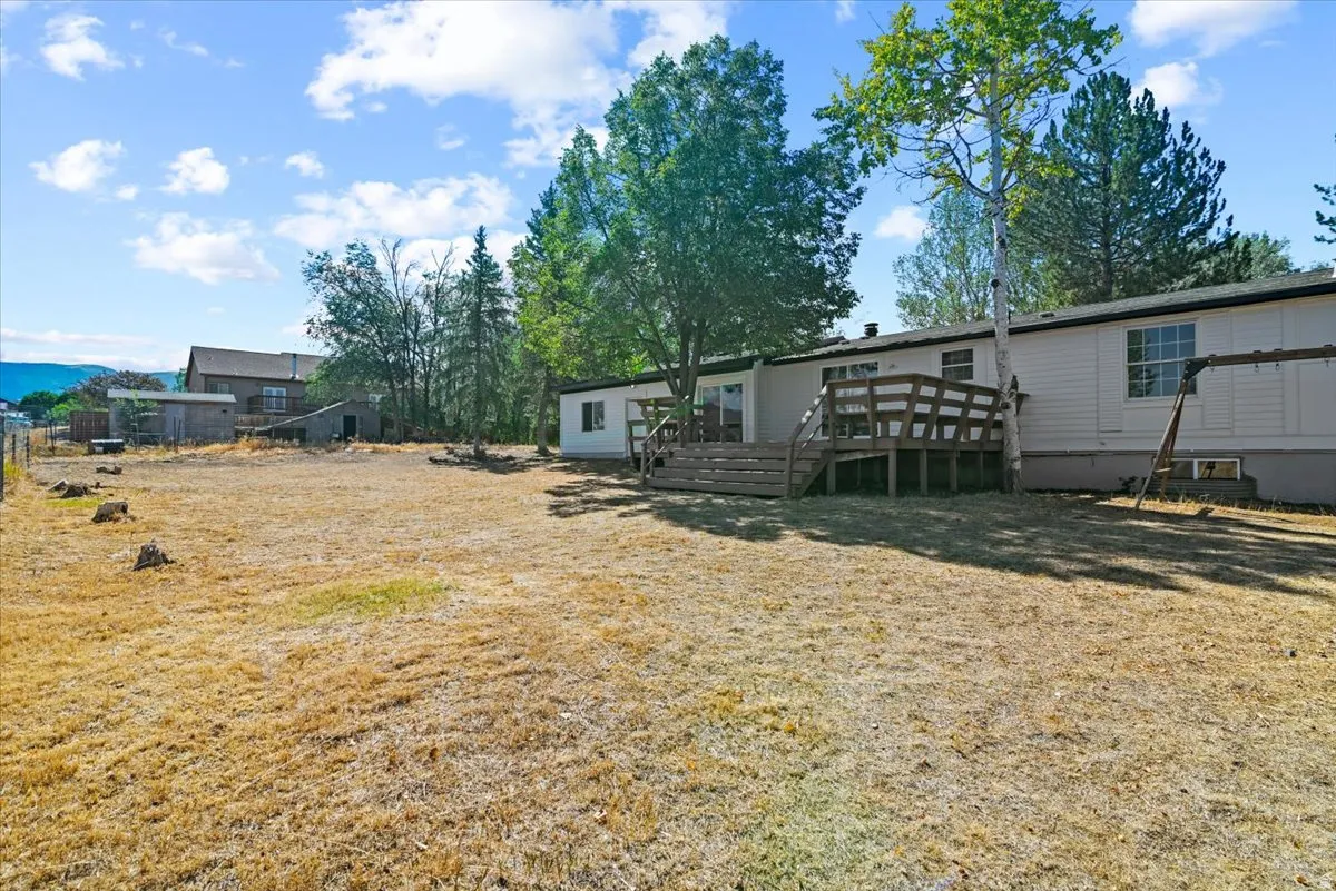 Expansive exterior with a wood deck and mature trees