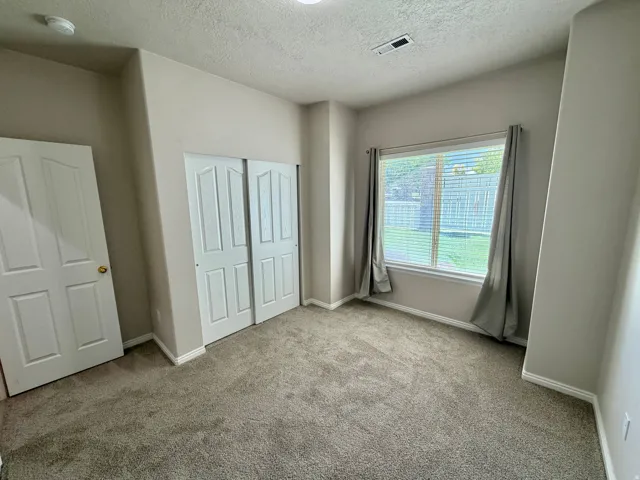 Recessed lighting, neutral-toned walls, and soft carpet flooring
