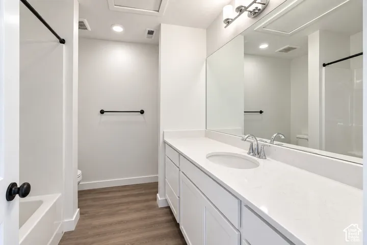 White vanity with a single basin, stainless steel faucet, and expansive countertop
