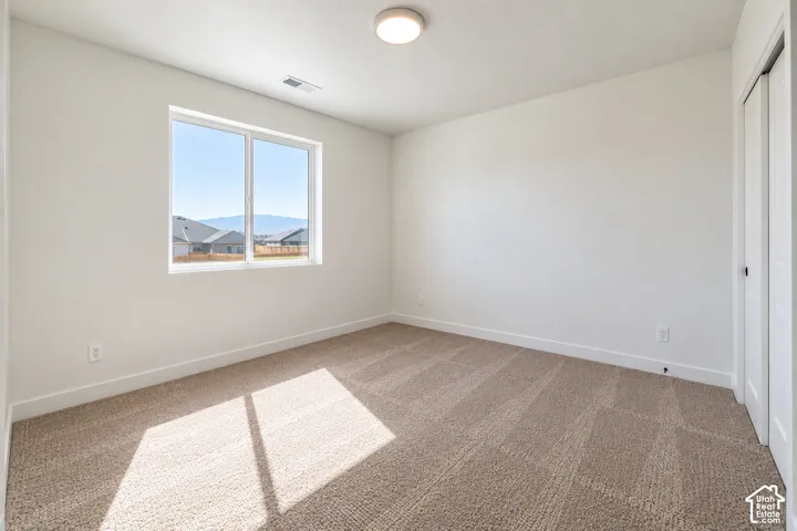Carpeted flooring, white walls, and a window with mountain scenery