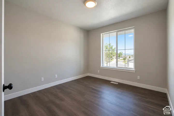 Neutral wall paint, wood-finish flooring, recessed lighting, and a large window with white trim