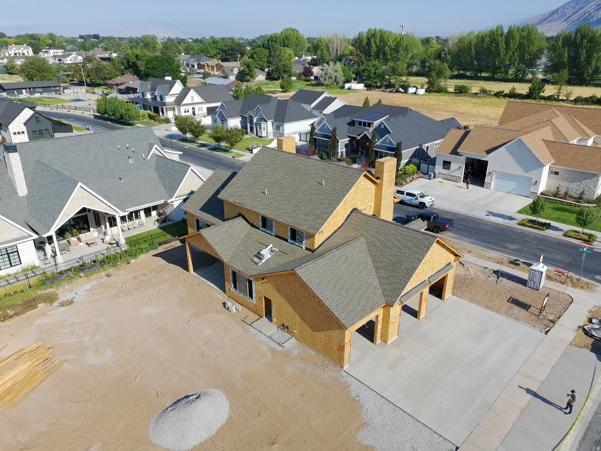 Newly constructed residence with a two-car garage, covered entry, and a prominent chimney feature