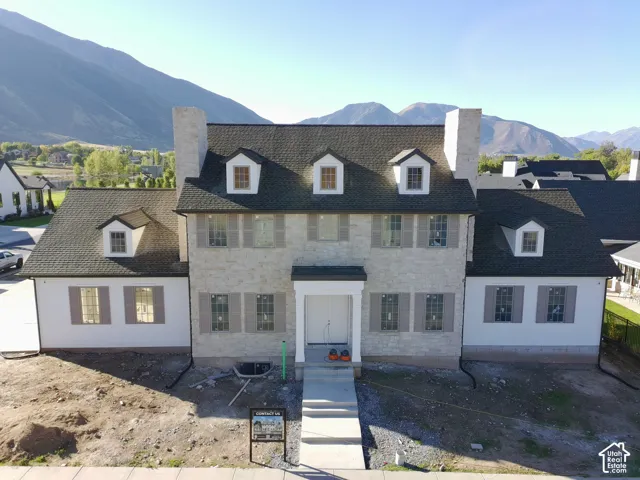 Stone facade with dormer windows and dark shingles