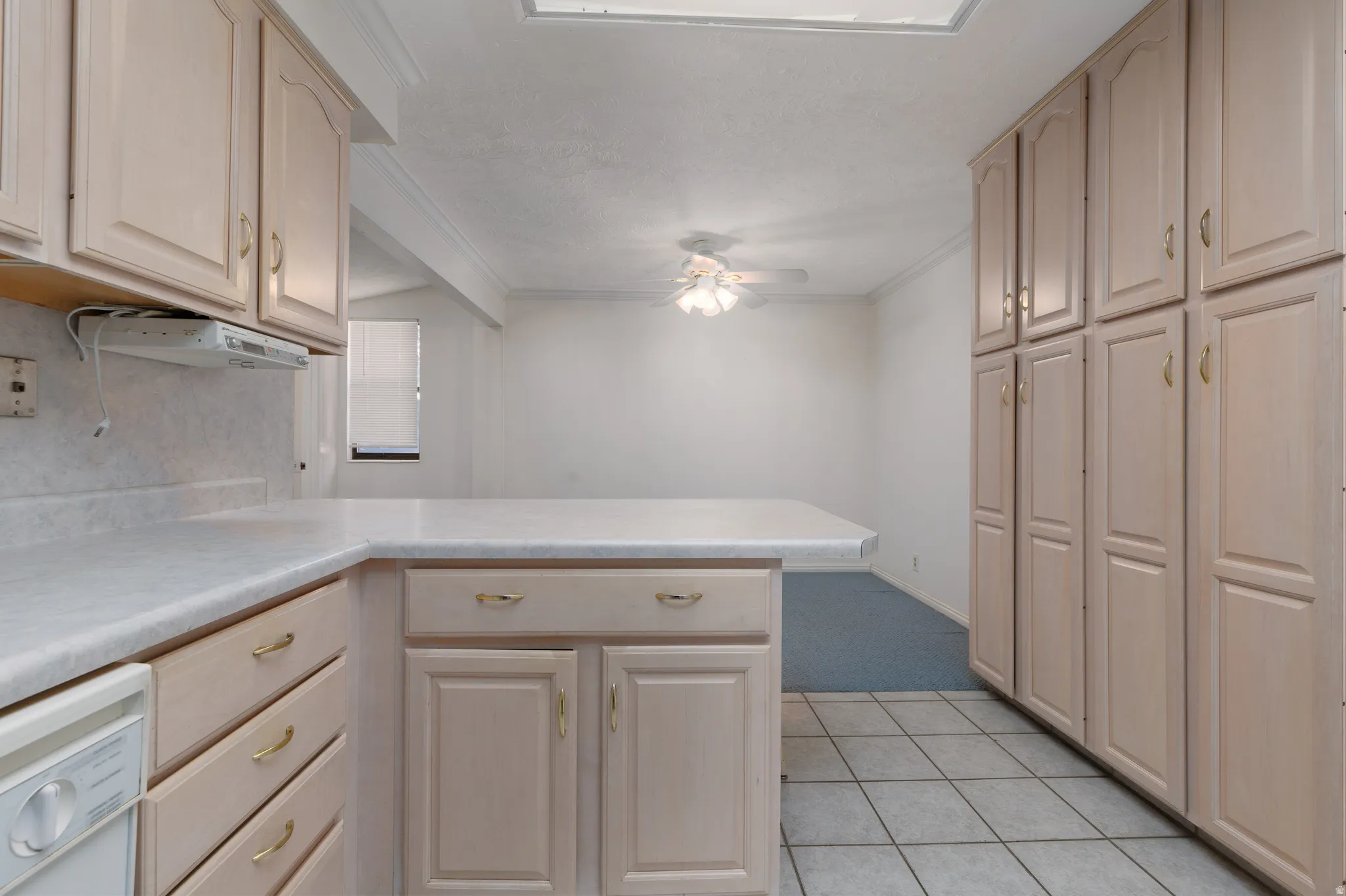 Kitchen featuring extensive cabinetry, laminate countertops, and tile flooring