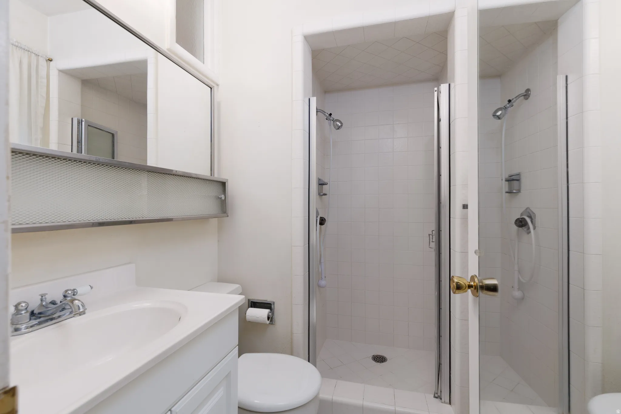 Bathroom vanity with integrated sink, chrome faucet, and a large wall-mounted mirror