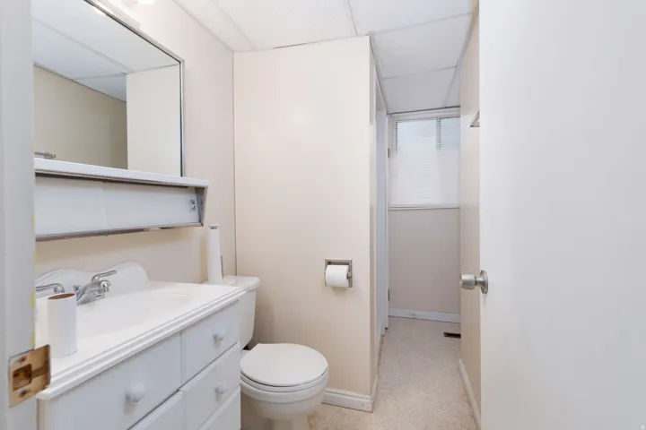 Bathroom featuring a vanity with integrated sink, chrome faucet, and a wall-mounted mirror