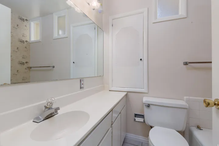 Bathroom vanity featuring a white countertop, integrated sink, and chrome faucet