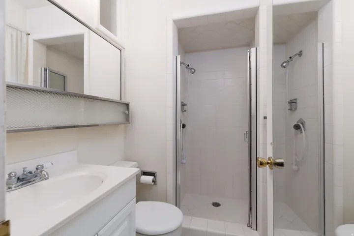 Bathroom vanity with integrated sink, chrome faucet, and a large wall-mounted mirror