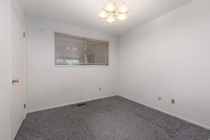 White walls complement the blue-grey carpeting