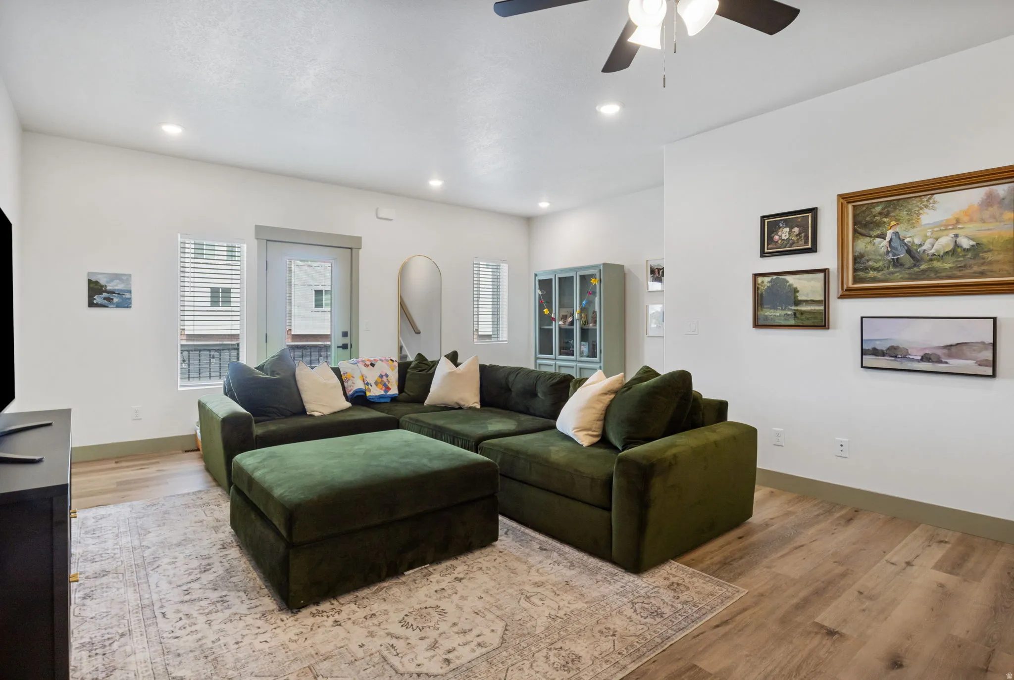 Recessed lighting, ceiling fan, hard-surface flooring, white walls, and a built-in display cabinet