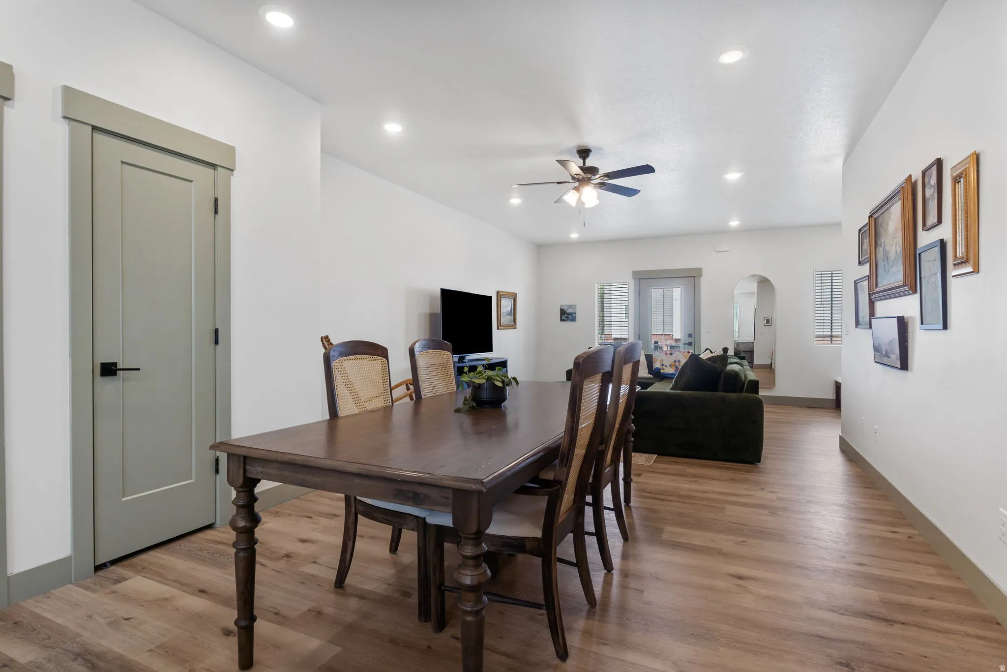 Open-concept living space featuring wood-finish flooring, recessed lighting, and a ceiling fan