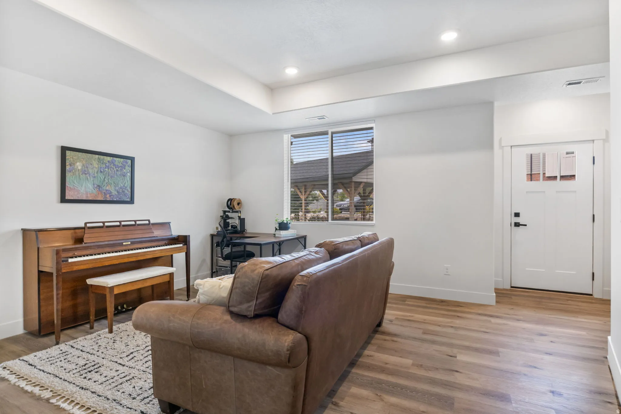 Recessed lighting, wood-finish flooring, white walls, and a multi-pane entry door