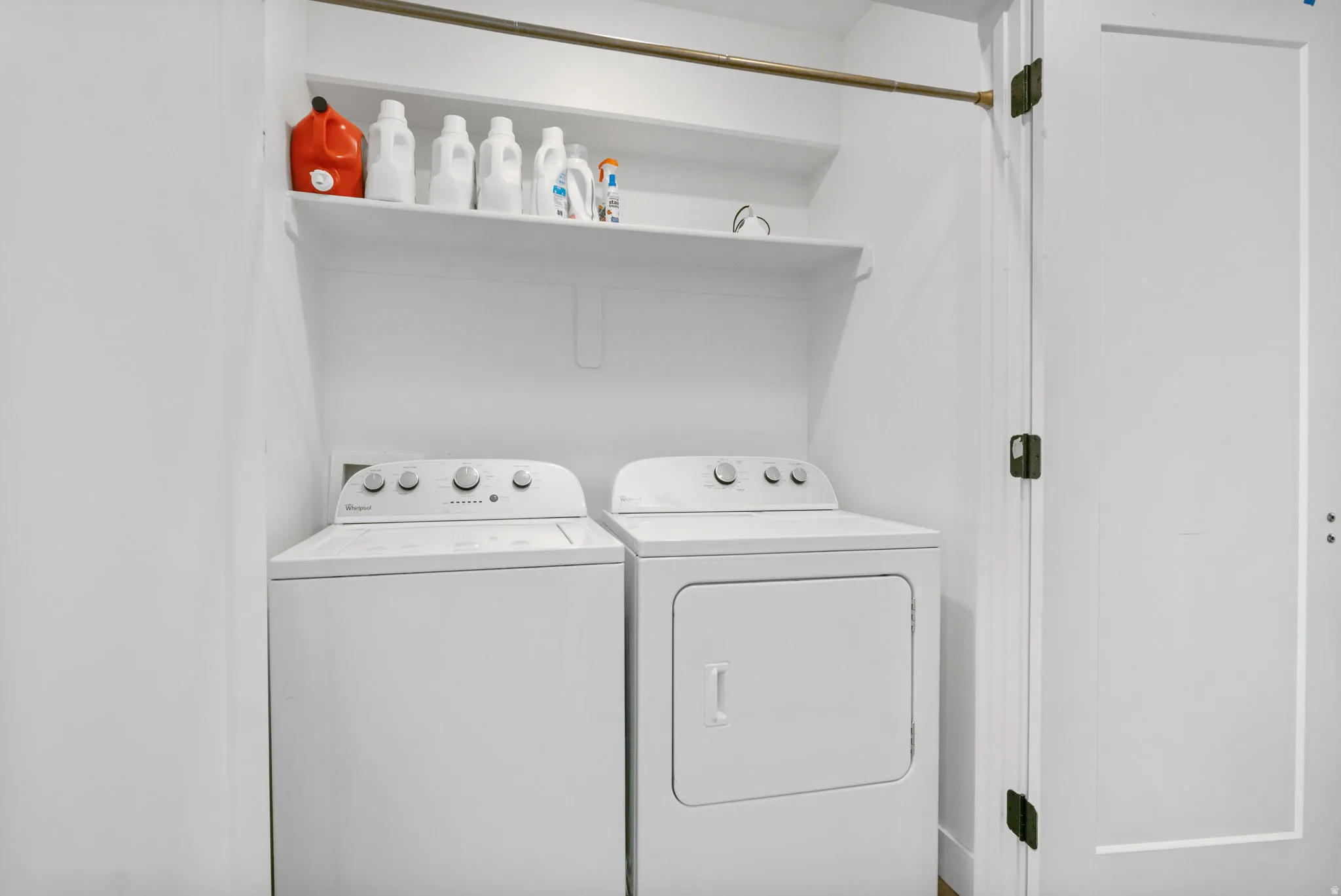 Dedicated laundry area with two wall-mounted storage shelves
