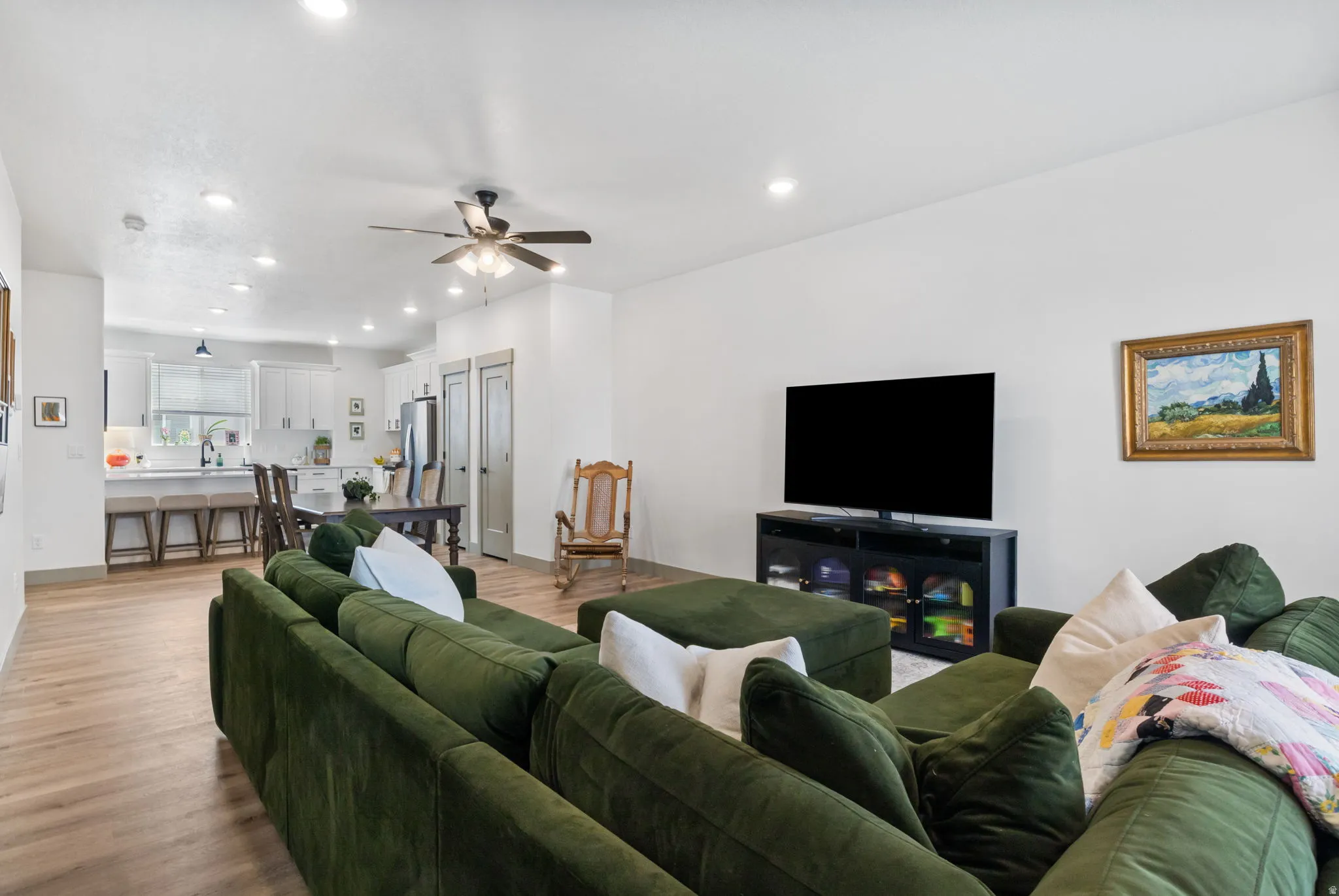 Open-concept living area featuring wood-finish flooring, recessed lighting, and a ceiling fan