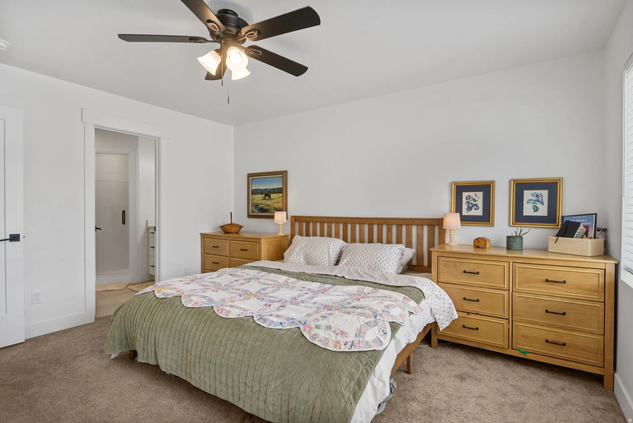 Plush carpeting, a ceiling fan with integrated lighting, showing doors to walk-in closet and bathroom