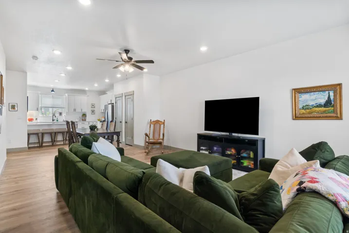 Open-concept living area featuring wood-finish flooring, recessed lighting, and a ceiling fan