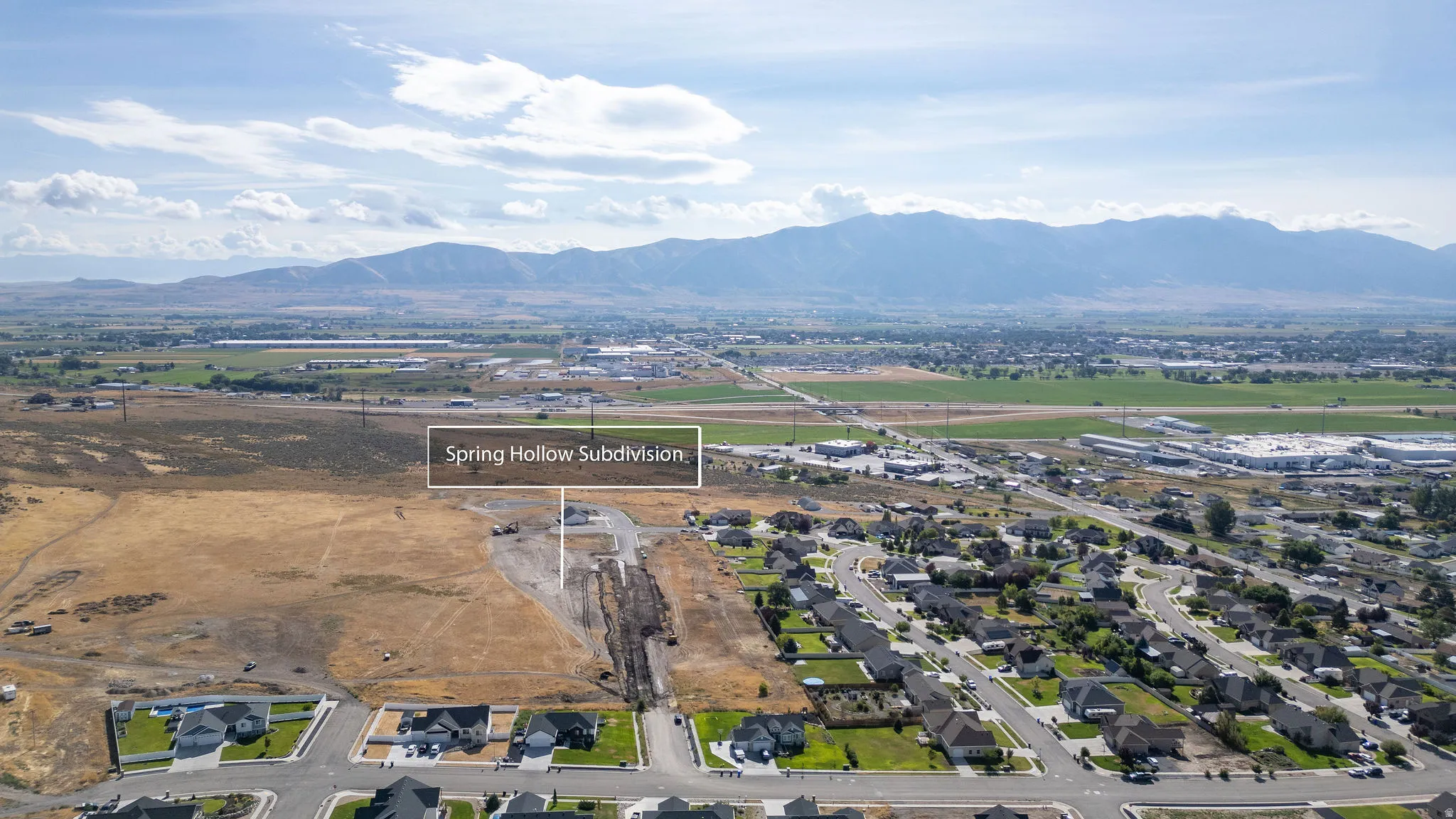 Aerial perspective showcasing a developing subdivision with established residential areas