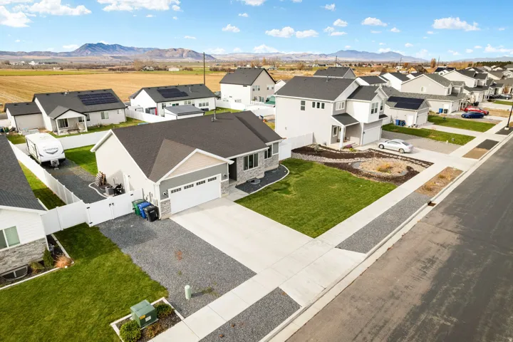 Single-story residence with a two-car garage, stone and siding exterior, and a gravel driveway