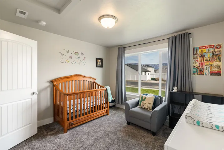 Room featuring a coffered ceiling, large window, broadloom carpeting, and a paneled door