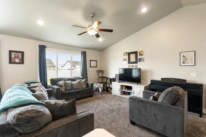 Vaulted ceilings, recessed lighting, and a ceiling fan fixture