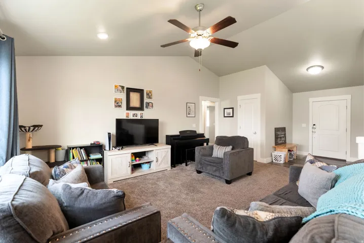 Vaulted ceilings, recessed lighting, and a ceiling fan create an inviting atmosphere
