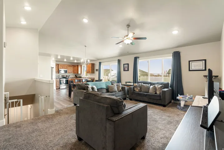 Open-concept living area with vaulted ceilings, recessed lighting, and large windows