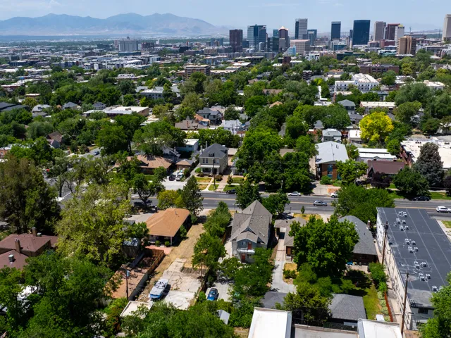 Expansive neighborhood setting with mature trees and mountain backdrop