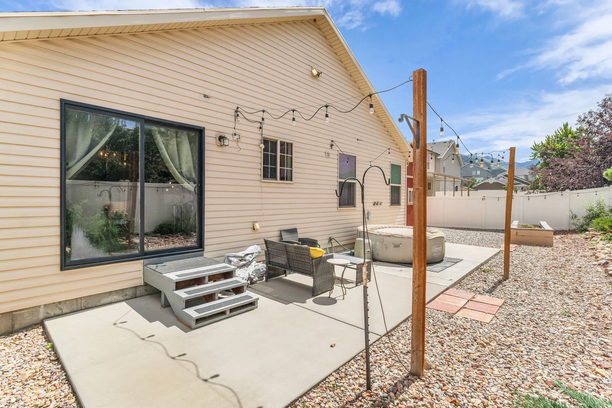 Large patio with exterior lighting, room for patio furniture and the inflatable hot tub