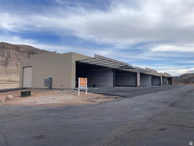 Modern stucco exterior with multiple overhead doors, providing expansive access