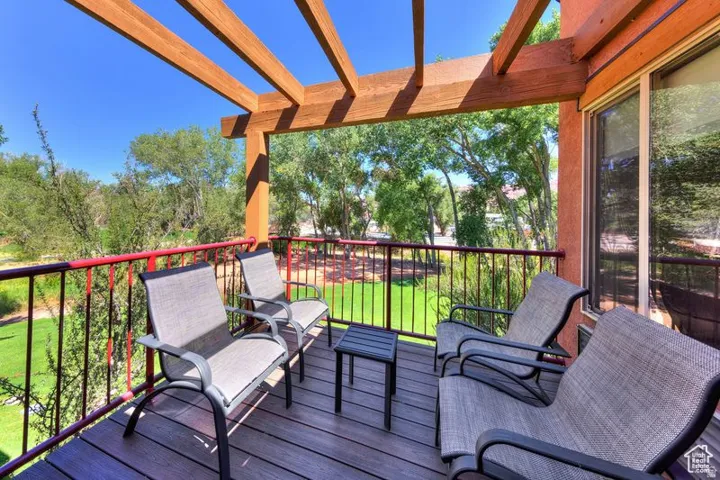 Exterior balcony featuring wood-finish decking and a wooden pergola