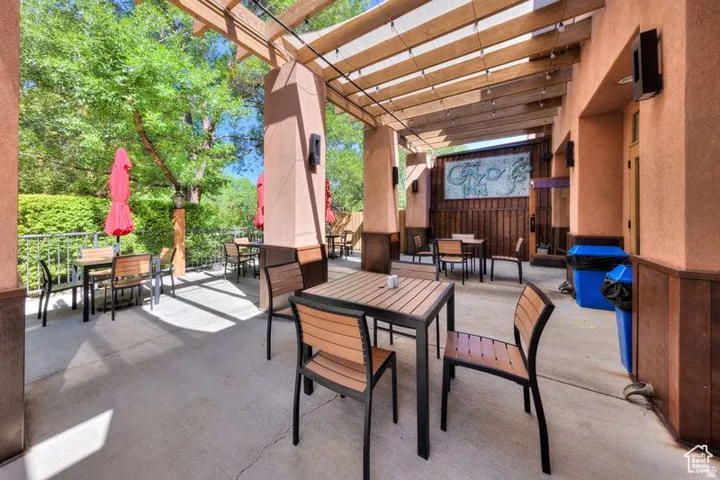 Expansive concrete patio with a wood pergola overhead